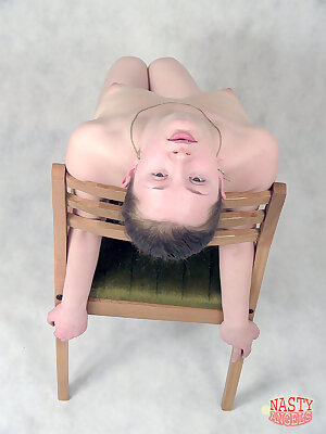 a naked man sitting on a chair with his head above his head and his hands behind his back and his head above his head with both hands on his and a wooden frame, with his head and hands behind his head